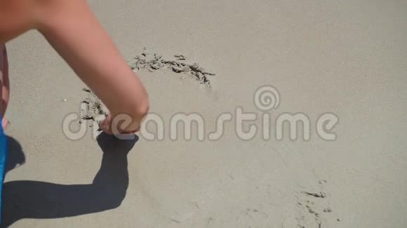 那个女孩在沙滩上画画在一个阳光明媚的日子里海浪正在冲刷着沙滩上的图案视频的预览图