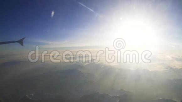阳光照耀在白雪皑皑的群山上从飞机上俯瞰高空视频的预览图