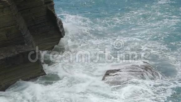 海浪冲破岩石悬崖形成海岸线的泡沫视频的预览图