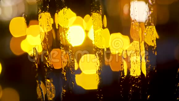 抽象模糊的夜晚城市灯光和雨滴在潮湿的玻璃后面视频的预览图
