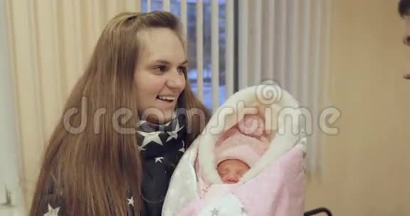 幸福的一对夫妇抱着一个新生婴儿站在医院里微笑视频的预览图