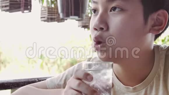 亚洲男孩的慢动作早餐后从杯子里喝水视频的预览图