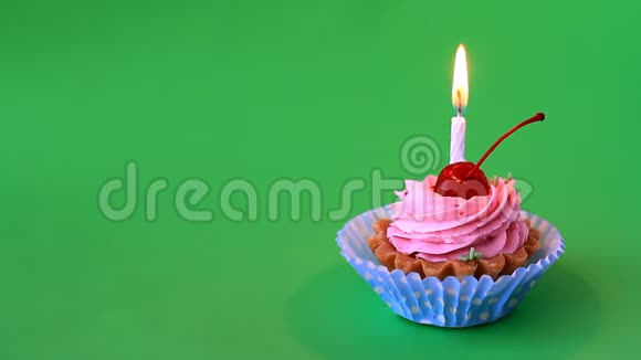 带有樱桃粉色奶油和绿色背景的生日蜡烛的生日蛋糕视频的预览图