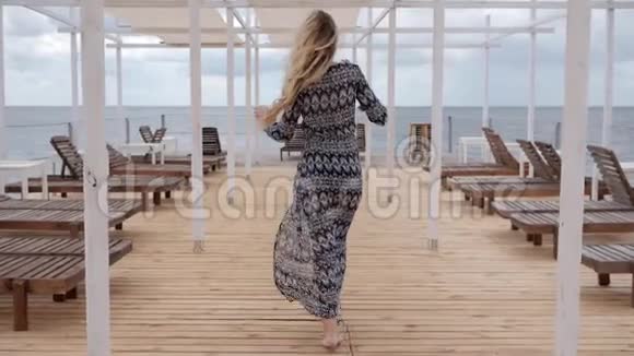 快乐的女人呼唤她海边的女人放暑假海边的女孩在迎风展衣视频的预览图