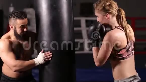 与一名学生一起训练拳击戴拳击手套的女孩正在打一拳视频的预览图