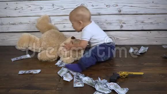 那孩子坐在地上地上堆满了钱上面有一只泰迪熊高清视频的预览图