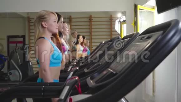 四名运动妇女在跑步机上进行慢动作射击视频的预览图