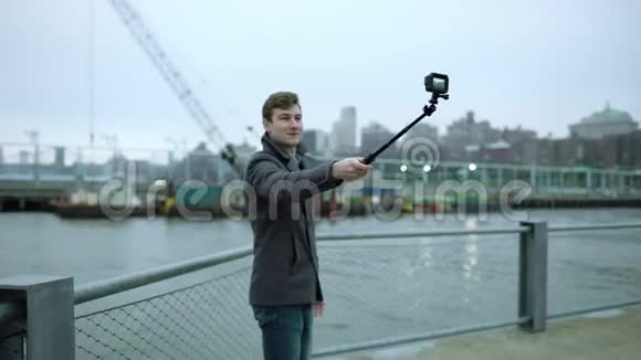 年轻游客用相机拍摄自己背景是曼哈顿的自拍棒视频的预览图