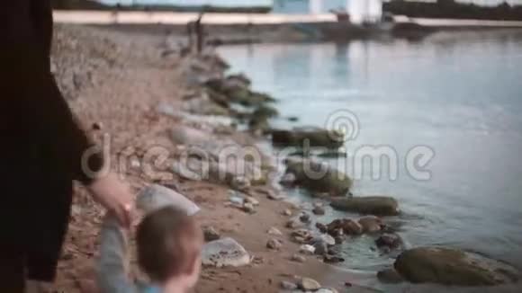 夕阳西下父子两人在沙滩上牵手漫步视频的预览图