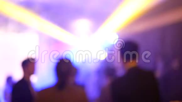 4K镜头的抽象模糊剪影组的人跳舞与五颜六色的光在聚会上与乐趣抽象的夜生活视频的预览图