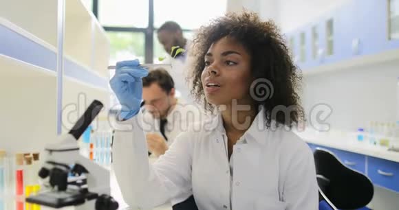 非裔美国科学家利用研究人员混合种族小组分析基因实验室中的植物工作视频的预览图