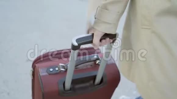 一个女人的手拿着把手提箱一个女人带着手提箱走到机场大楼一家企业视频的预览图