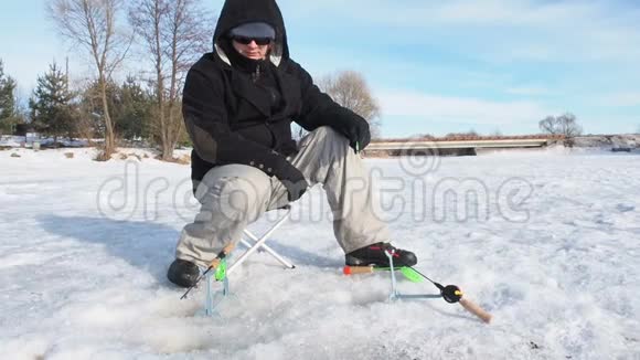渔民钻洞在冰上近景运动钓鱼在冬天视频的预览图