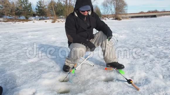 渔民钻洞在冰上近景运动钓鱼在冬天视频的预览图