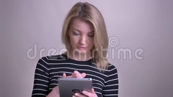 使用平板电脑和相机微笑的白种人成年金发女性特写镜头视频的预览图