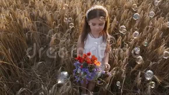 日落时麦田里的小女孩带着一束野花视频的预览图