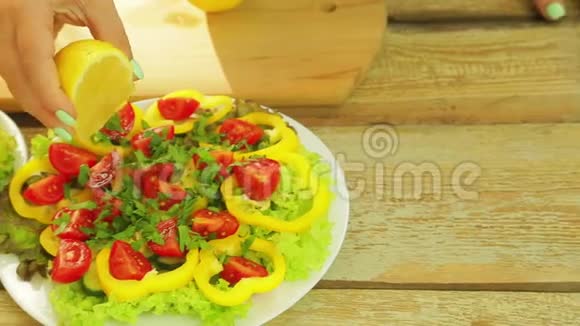 一个女人用蔬菜沙拉把柠檬里的汁挤到盘子里视频的预览图