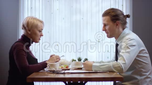 两个年轻人在咖啡馆里一起工作他们吃商务午餐餐馆里的女人和男人视频的预览图