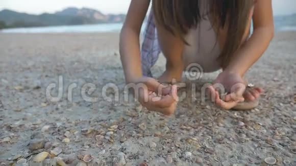 亚洲小孩在沙滩上捡贝壳视频的预览图