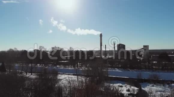 雪的冬天里的老企业建筑基地机库空中射击污染空气的烟囱管式锅炉赢了视频的预览图