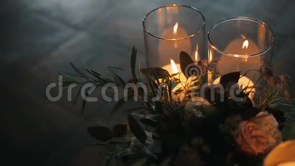 用漂亮的花束在镶花地板上点燃蜡烛蜡烛在眼镜里燃烧视频的预览图