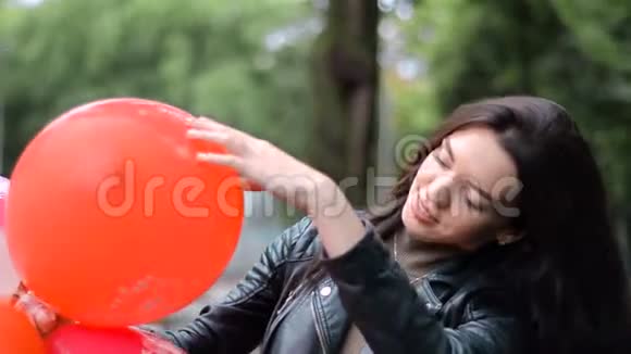 美丽的黑发女人拿着一大堆气球微笑着视频的预览图