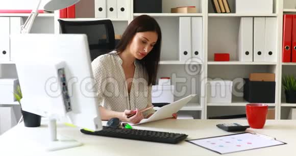 女商人坐在办公室椅子上看文件视频的预览图