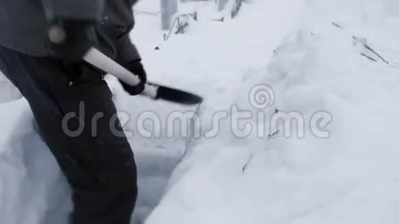 无法辨认的人用铲子清理白雪视频的预览图