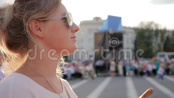 戴太阳镜的女孩手臂上的手机特写戴眼镜的女人看照片手机外门视频的预览图