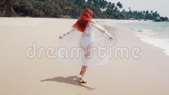 阳光明媚的一天年轻女子沿着海边奔跑视频的预览图