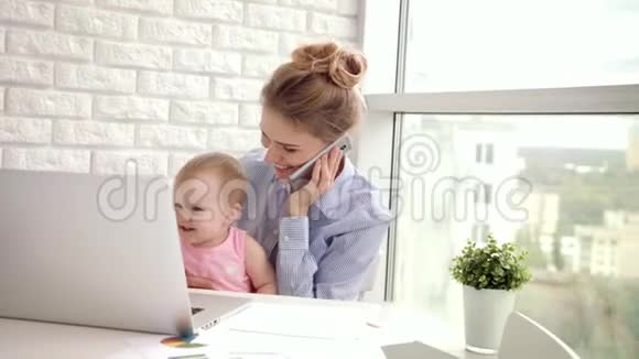 带着婴儿说话电话的工作女人有孩子的商业妈妈视频的预览图