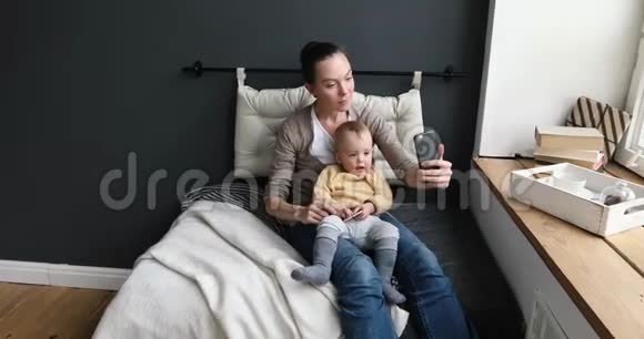 妈妈和幼儿在舒适的客厅自拍视频的预览图