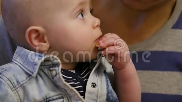 一个小男孩坐在他父亲怀里自己吃了一个苹果慢动作1920x1080全高清视频的预览图