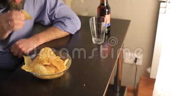 看足球赛的人倒啤酒吃薯片视频的预览图