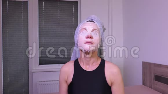 戴面膜的女人坐在床上视频的预览图