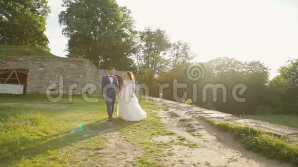 可爱的新婚夫妇走在城堡附近慢慢地视频的预览图
