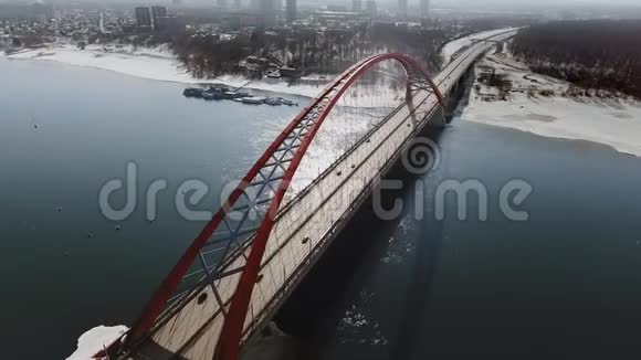 蓝色河流上空悬索桥的鸟瞰图与城市在雾中的后围日光从直升机上射击视频的预览图