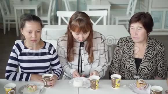 一支友好的女队在咖啡馆喝杯茶那个女孩正在吃蛋糕美味的茶甜点视频的预览图