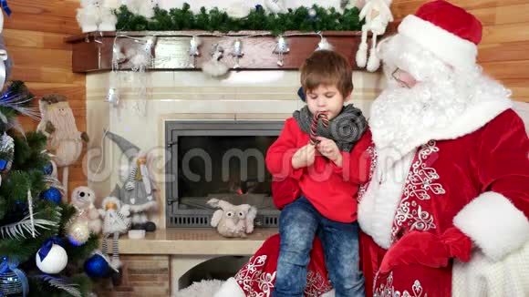 坐在圣诞老人腿上的孩子访问圣尼古拉斯的住所带着圣诞甜蜜的小男孩视频的预览图