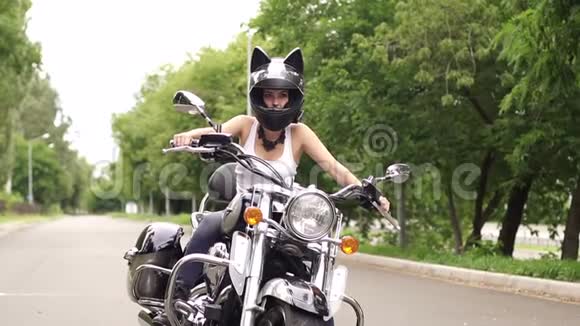 女孩坐在一辆戴着猫耳朵头盔的摩托车上视频的预览图