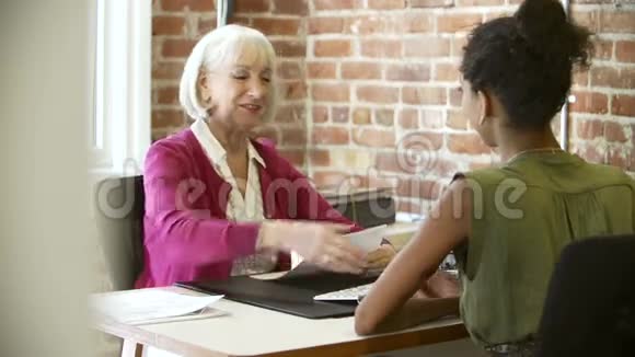 年长女商人在办公室采访年轻女视频的预览图