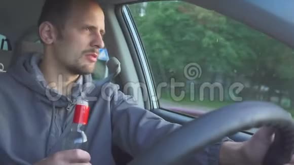 喝醉的司机在车里喝伏特加的男人道路上的危险视频的预览图