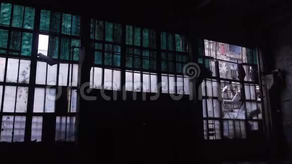 白天一个黑暗的机库里有破窗的旧废弃建筑的墙壁全景视频的预览图