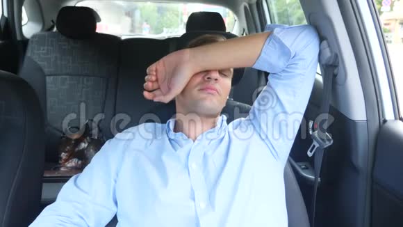 那个人的司机在繁忙路边的驾驶座上睡着了在车里等着视频的预览图