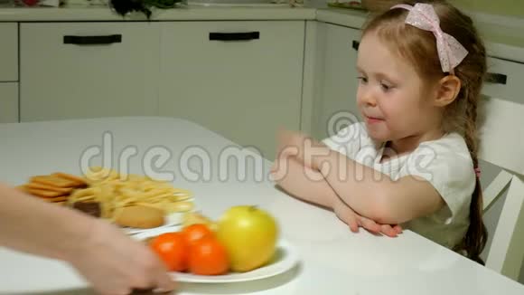 一个漂亮可爱的女孩拒绝一盘零食巧克力薯片吃一盘水果一幅肖像画视频的预览图