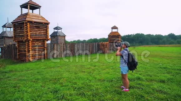 一位女游客拿着相机拍摄一座木制堡垒视频的预览图