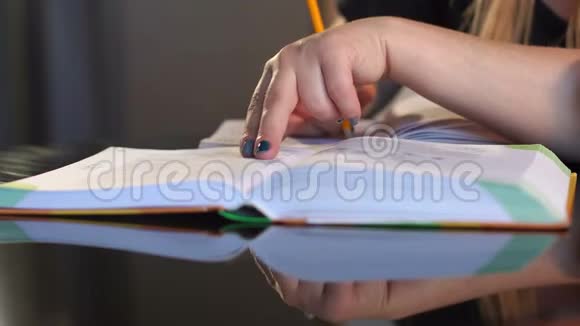 学生在笔记本上做笔记读一本书视频的预览图