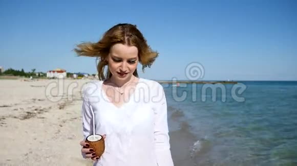 女孩在手机上做自拍喝椰子鸡尾酒视频的预览图