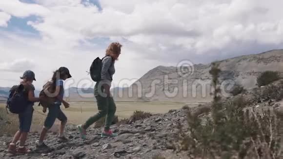 一群旅行者上山山里的家庭旅行者妈妈和两个孩子去远足了视频的预览图