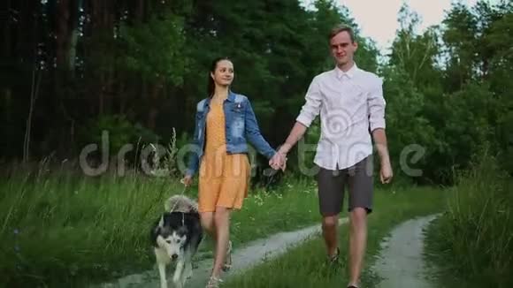 一对爱狗的夫妇哈斯基马拉穆特日落森林视频的预览图